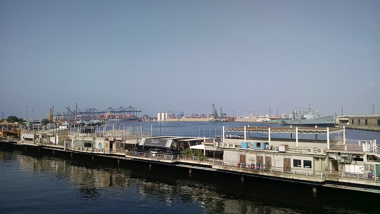 Stacks of shipping containers and cranes at a port in Karachi.