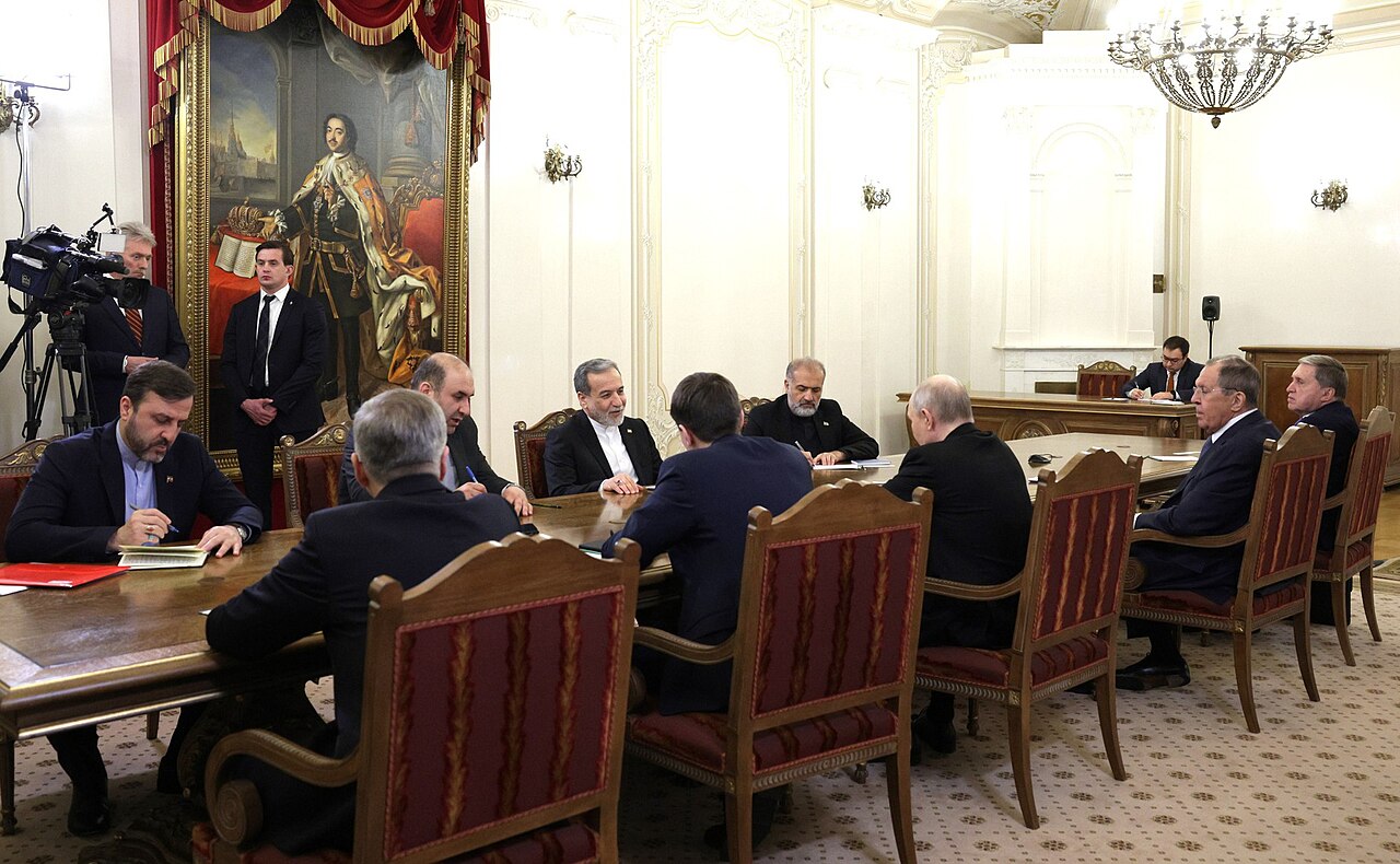 Russian President Vladimir Putin meeting Iranian Foreign Minister Abbas Araghchi at a diplomatic meeting.