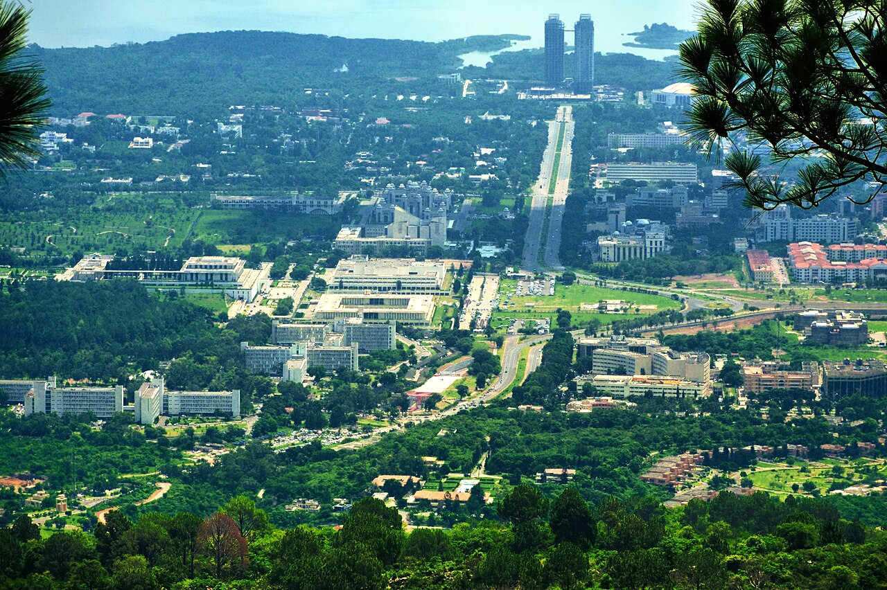 A panoramic view over Islamabad with Constitution Avenue running through the tree-lined city below.