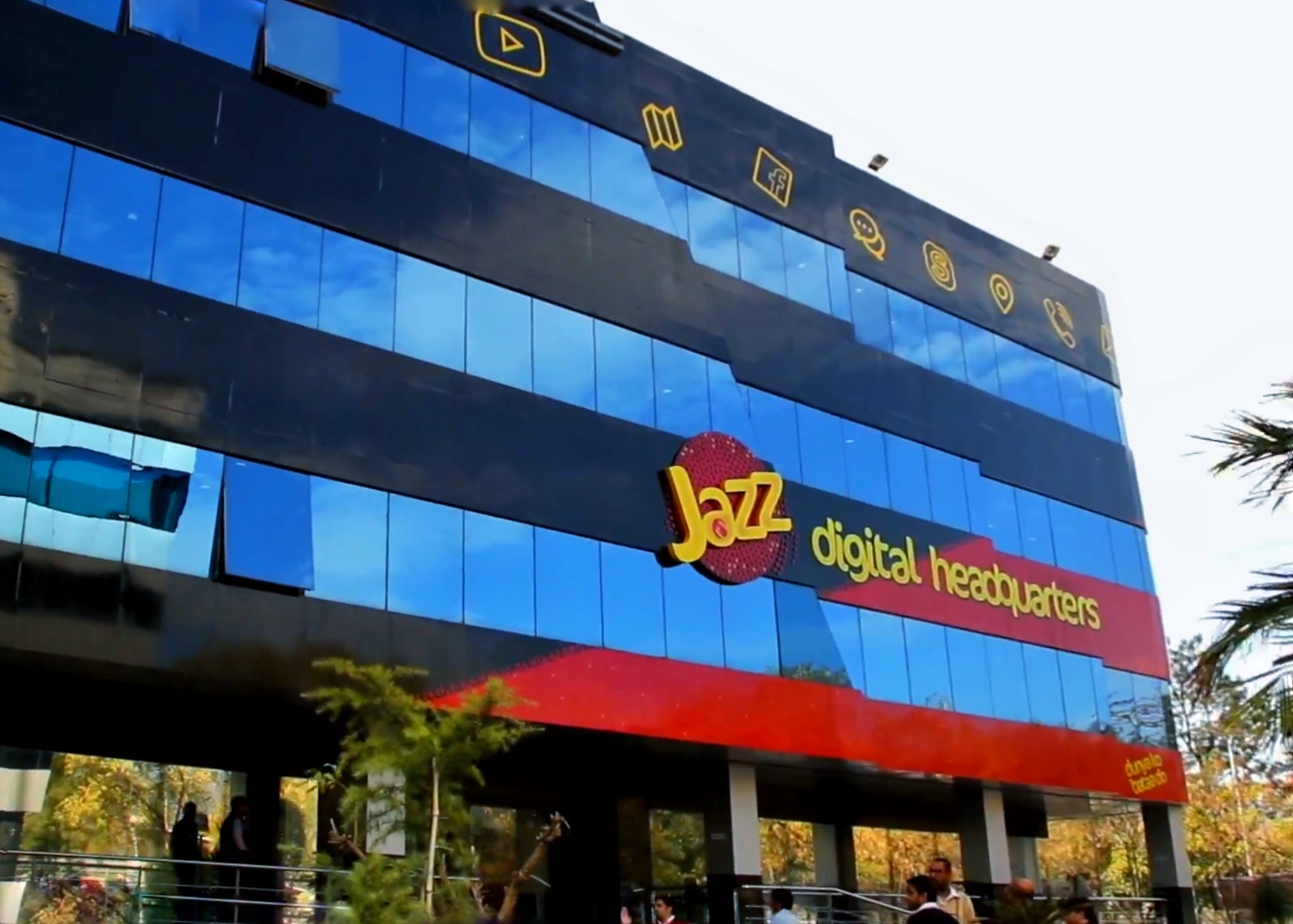The glass-fronted Jazz digital headquarters in Islamabad, with the yellow Jazz logo and 'digital headquarters' lettering on a blue and red facade.