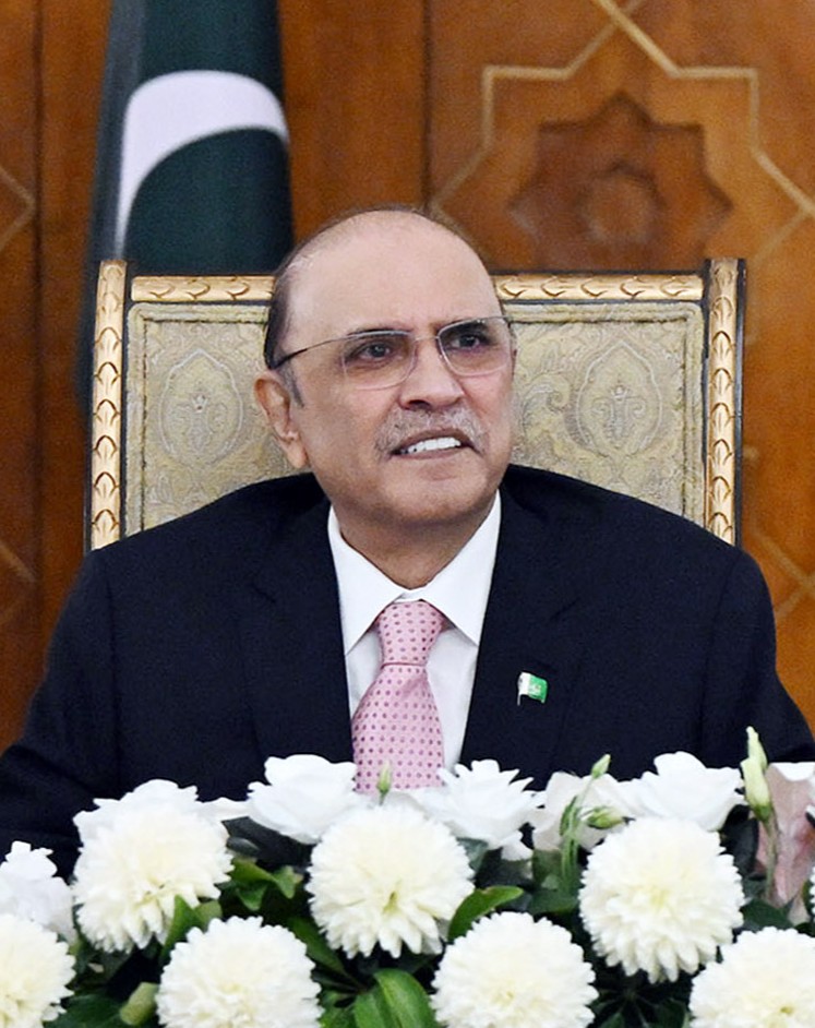A portrait of President Asif Ali Zardari wearing a dark suit and tie against a dark background.